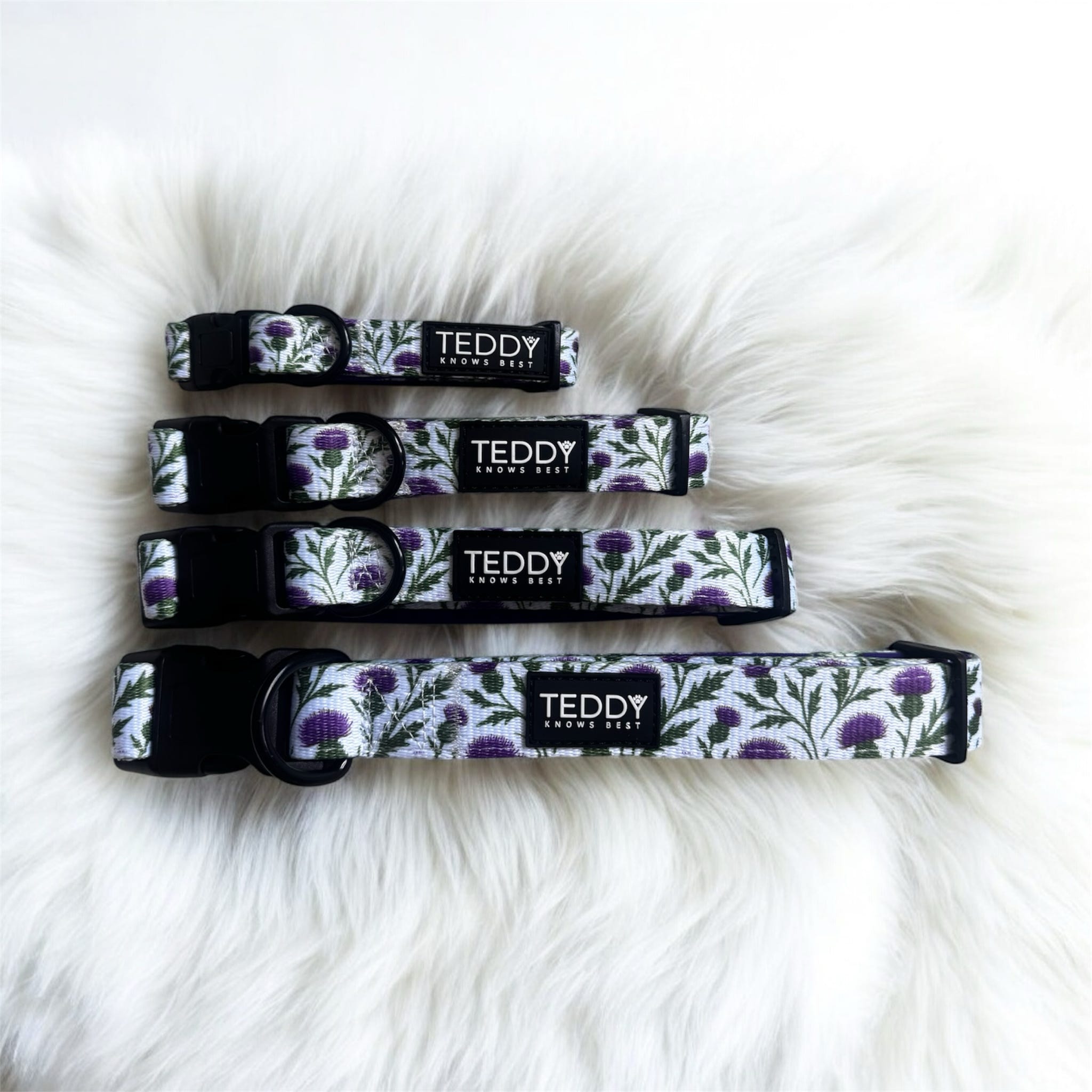 Set of four dog collars with floral pattern on a fluffy white surface