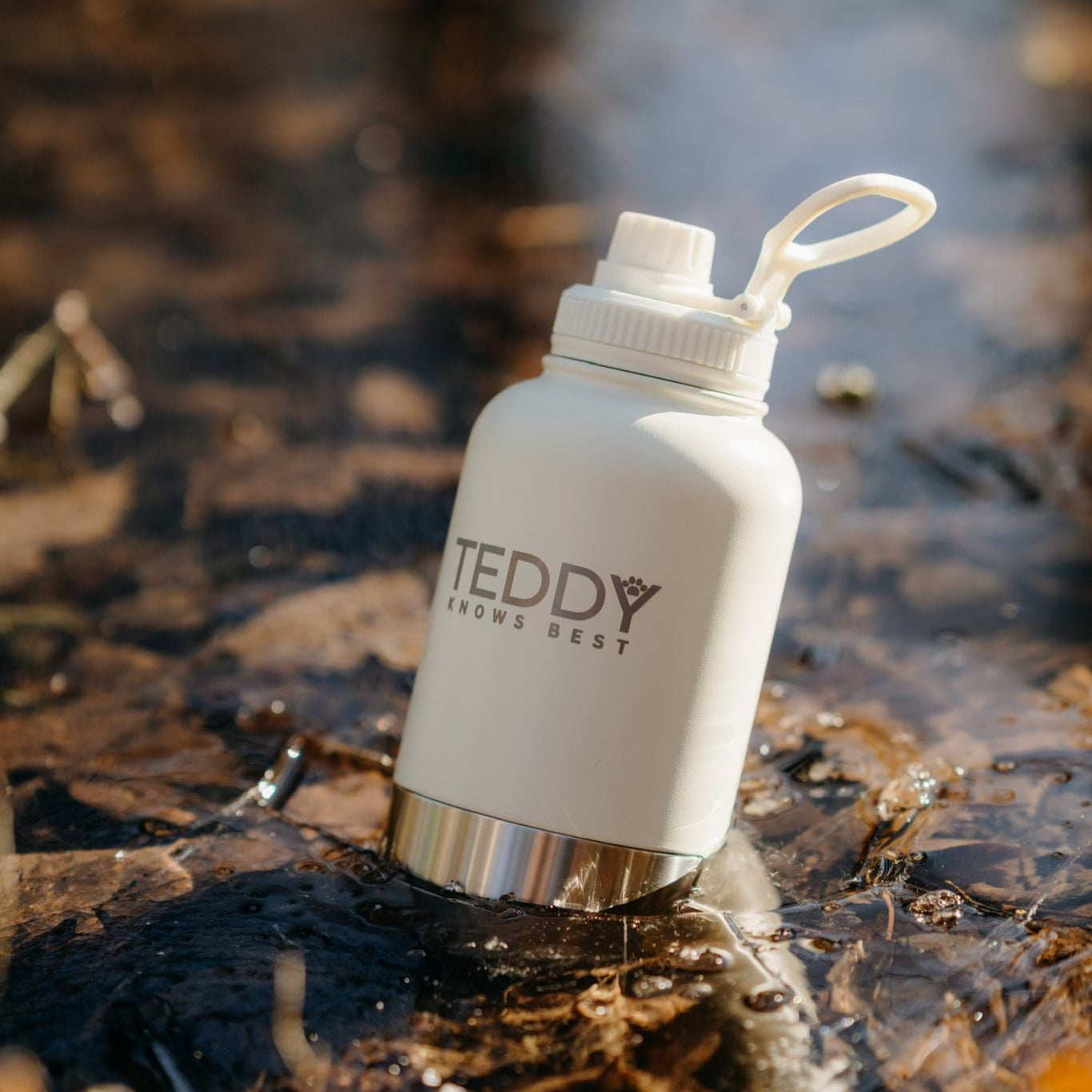 white 3 in 1 portable water bottle for dogs sitting in the ice