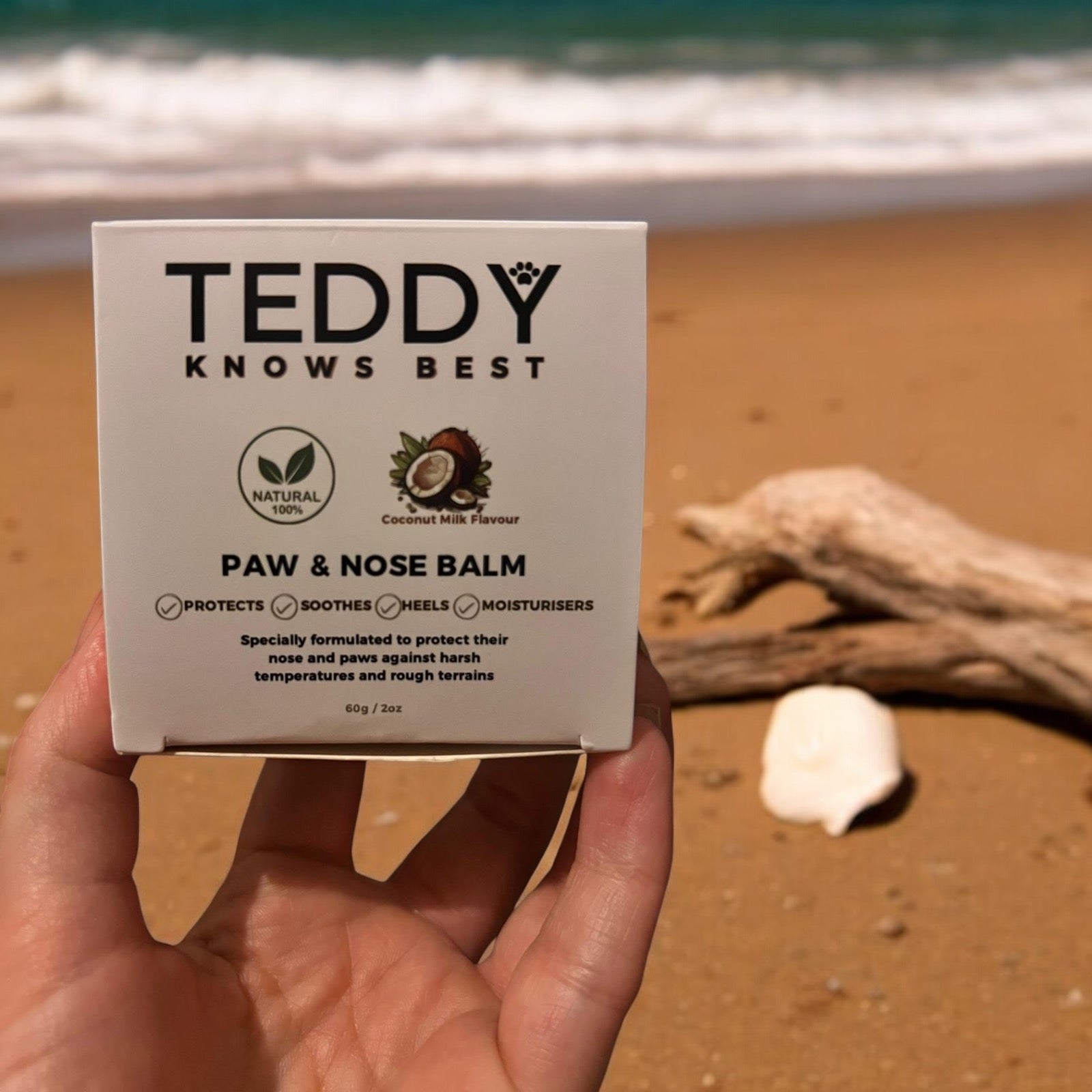 The box for the paw and nose balm with the beach in the background