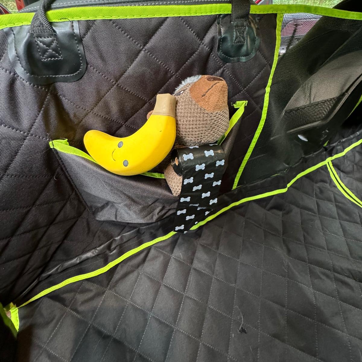 Car seat cover pockets filled with toys and poo bags