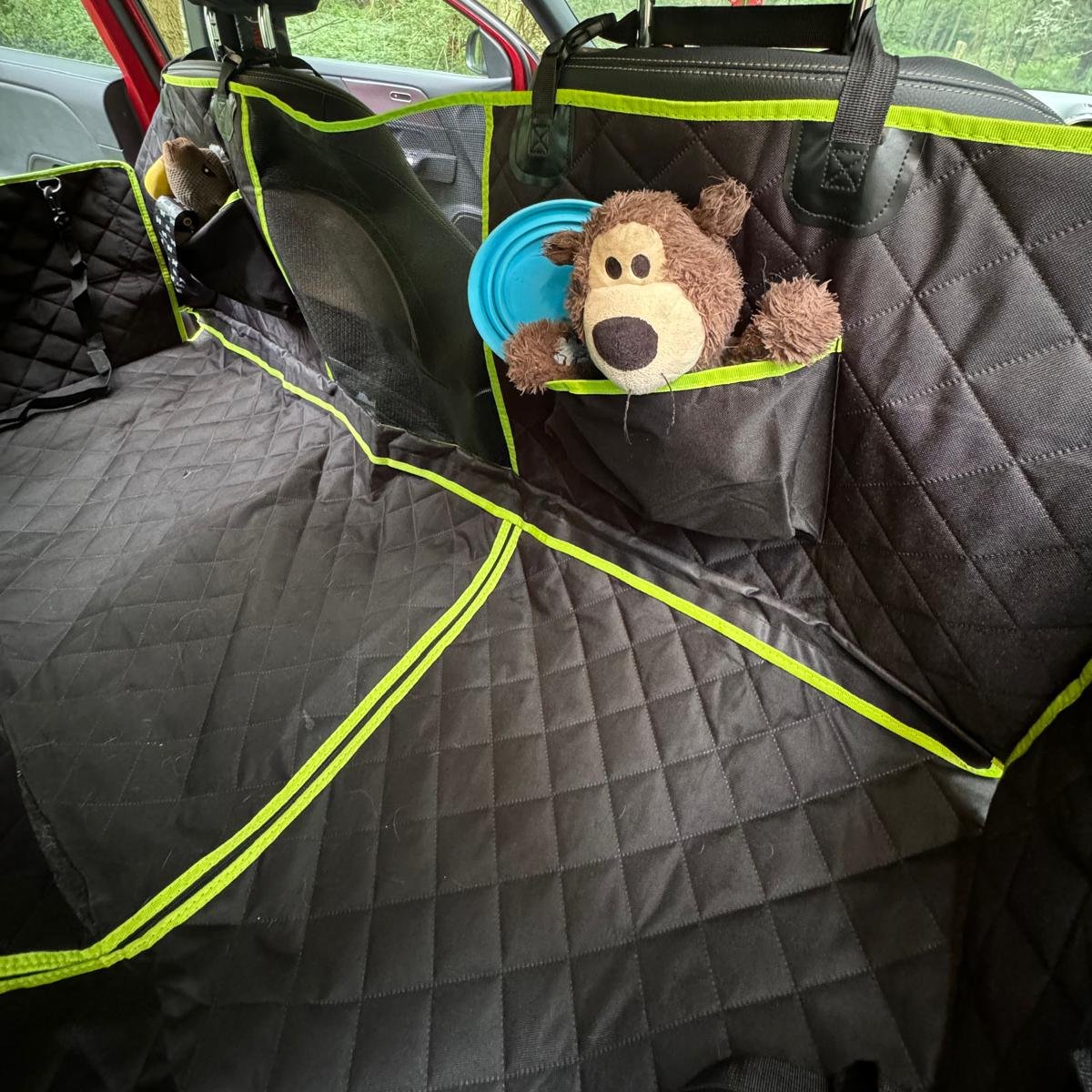 Car seat cover pockets filled with toys and a portable water bowl