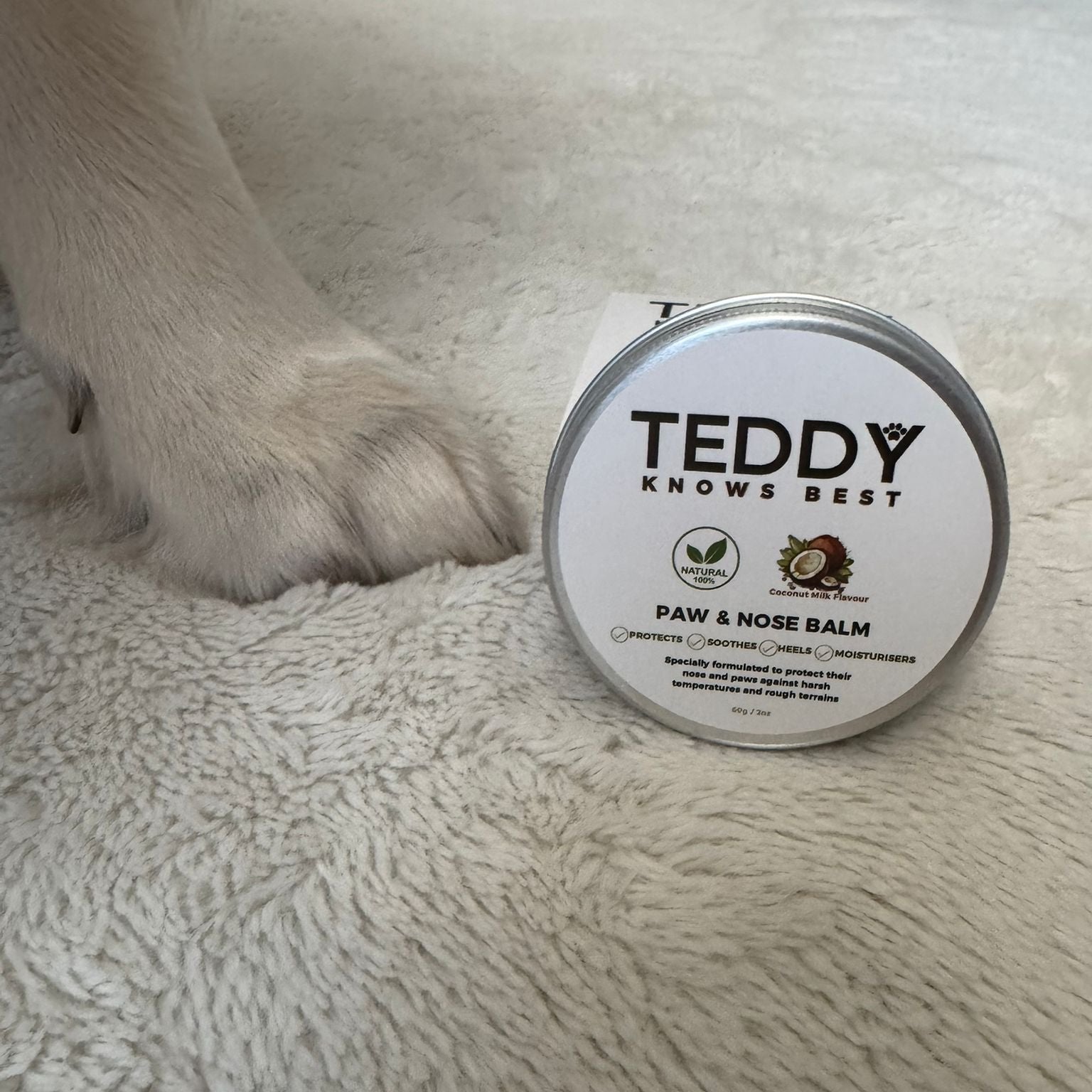 Dog paw next to Teddy Knows Best Paw and Nose Balm